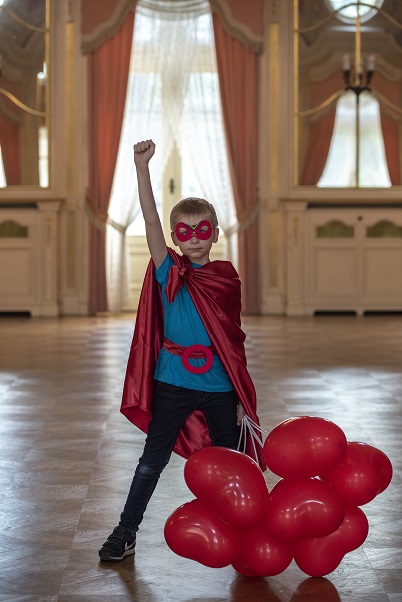 OKNO Grzes w stroju supermena z triumfalnym gestem Program OKNO kwartalnik0223