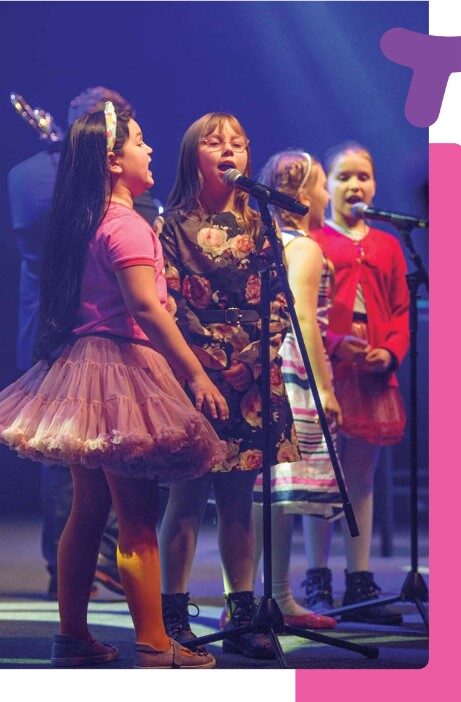 25-lecie fundacji grupa dzieci śpiewająca na scenie podczas balu raport2023